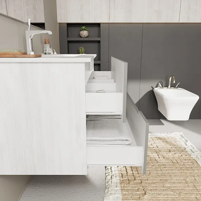 Kiamami Valentina Badmöbel-Set - Grau - Weißer Badwaschtisch mit Holzstruktur, offene Schubladen mit Handtüchern, neben Bidet und Teppich.