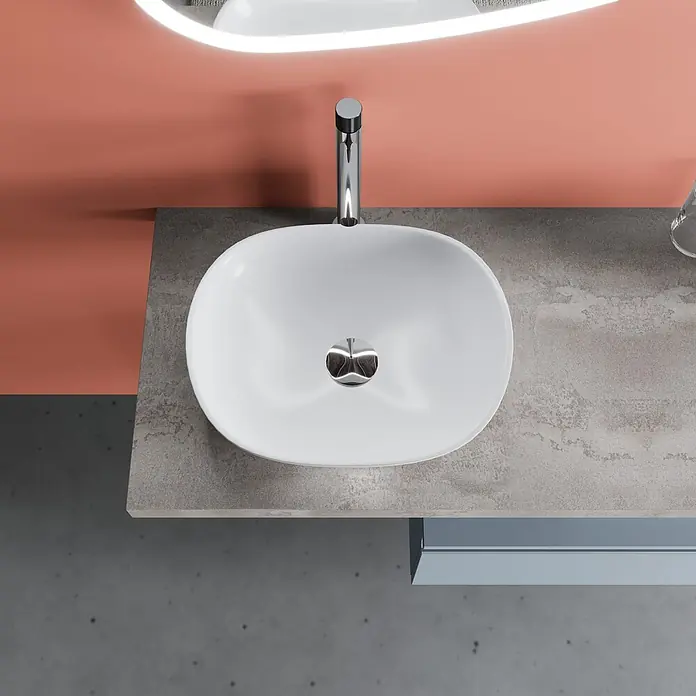 Kiamami Valentina Badmöbel-Set - Hellblau - Weißes ovales Waschbecken mit Chromarmatur und Ablauf auf einer grauen Arbeitsplatte in modernem Badezimmer.