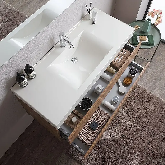Kiamami Valentina Badmöbel-Set - Braun - Moderner weißer Badezimmerschrank mit integriertem Waschbecken und zwei offenen Holzschubladen, organisiert mit Toilettenartikeln.