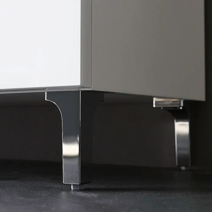 Kiamami Valentina Badmöbel-Set - Weiß - Polierte Metallmöbelfüße mit gebogenen Halterungen unter einem hellgrauen Schrank.