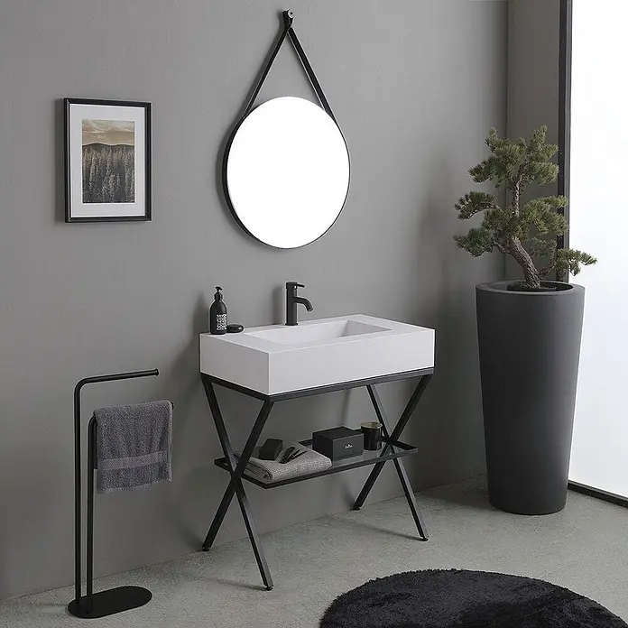 Kiamami Valentina Badmöbel-Set - Weiß - Moderner Badwaschtisch mit weißem Rechteckbecken, schwarzem Wasserhahn und schwarzem Metallrahmen. Darüber hängt ein runder, schwarz gerahmter Spiegel.