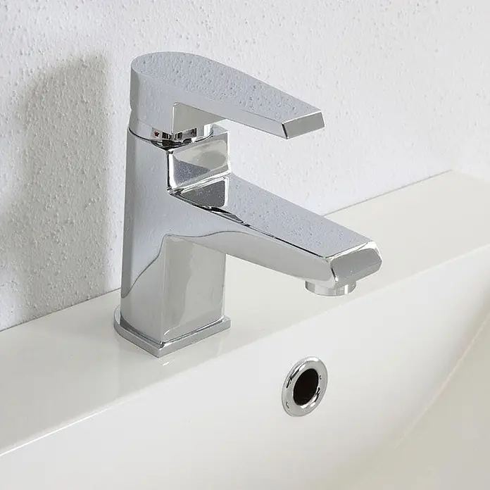 Kiamami Valentina Badmöbel-Set - Grau - Moderner Einhebelmischer aus Chrom mit Wassertropfen, auf einem weißen Waschbecken montiert.