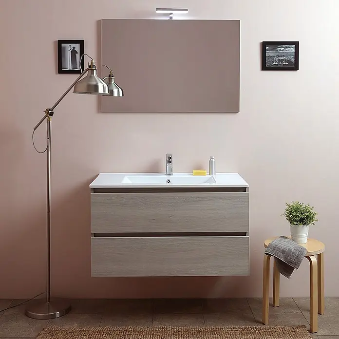 Kiamami Valentina Badmöbel-Set - Helles Holz - Wandhängender Badwaschtisch in heller Holzoptik mit weißem Becken, unter einem rechteckigen Spiegel mit Licht.