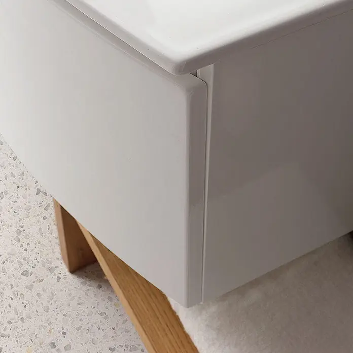 Kiamami Valentina Badmöbel-Set - Weiß - Weißglänzender Schrank mit glatter Oberfläche und natürlichem Holzsockel.