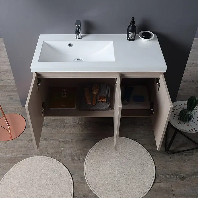 Kiamami Valentina Badmöbel-Set - Beige - Moderner Waschtisch aus hellem Holz mit weißer Platte und integriertem Waschbecken, offene Schranktüren zeigen Stauraum.