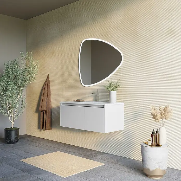 Kiamami Valentina Badmöbel-Set - Grau - Weiße, wandmontierte Badmöbel mit integriertem Waschbecken und modernem, unregelmäßigem Spiegel in einem minimalistischen Badezimmer.