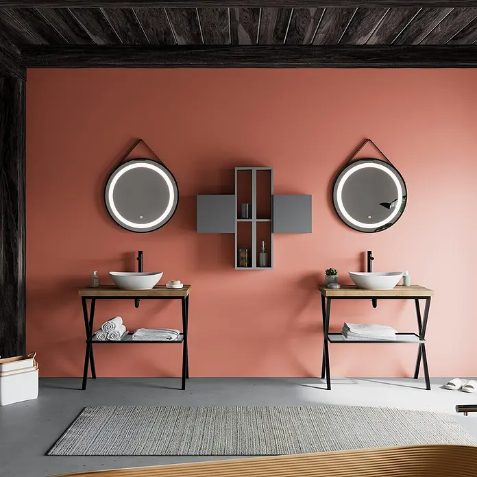 Kiamami Valentina Badmöbel-Set - Grau - Modernes Badezimmer mit zwei Waschtischen, beleuchteten Spiegeln und einem modularen Regal an einer korallfarbenen Wand.