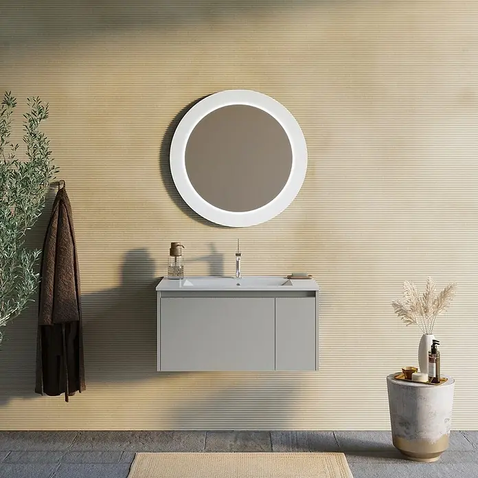 Kiamami Valentina Badmöbel-Set - Beige - Wandhängender grauer Badschrank mit weißem Waschbecken und rundem beleuchteten Spiegel in einem modernen Bad.