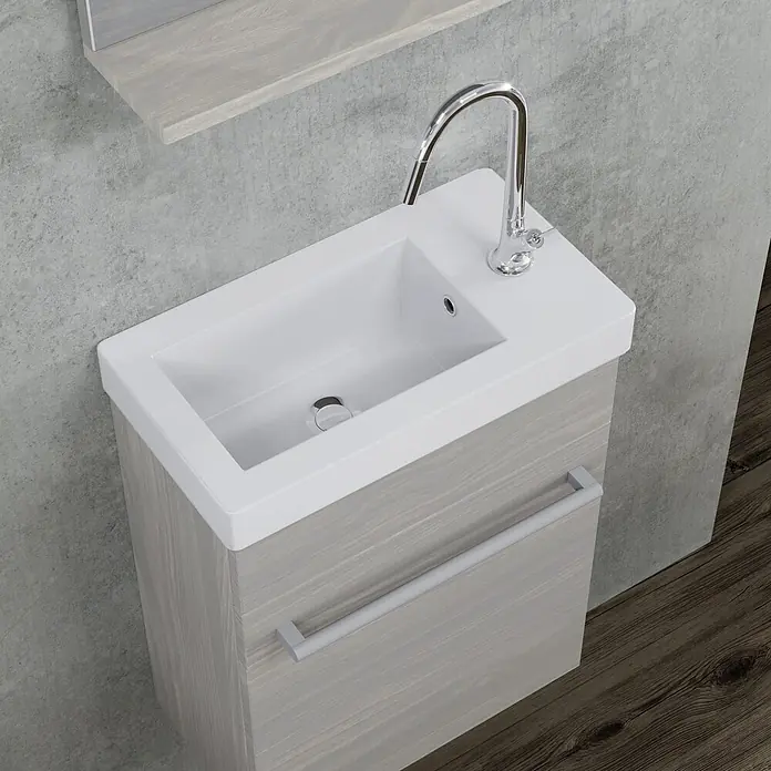 Kiamami Valentina Badmöbel-Set - Helles Holz - Moderner Waschtisch aus hellem Grauholz mit weißem integriertem Waschbecken, Chromarmatur und silbernem Griff im Badezimmer.