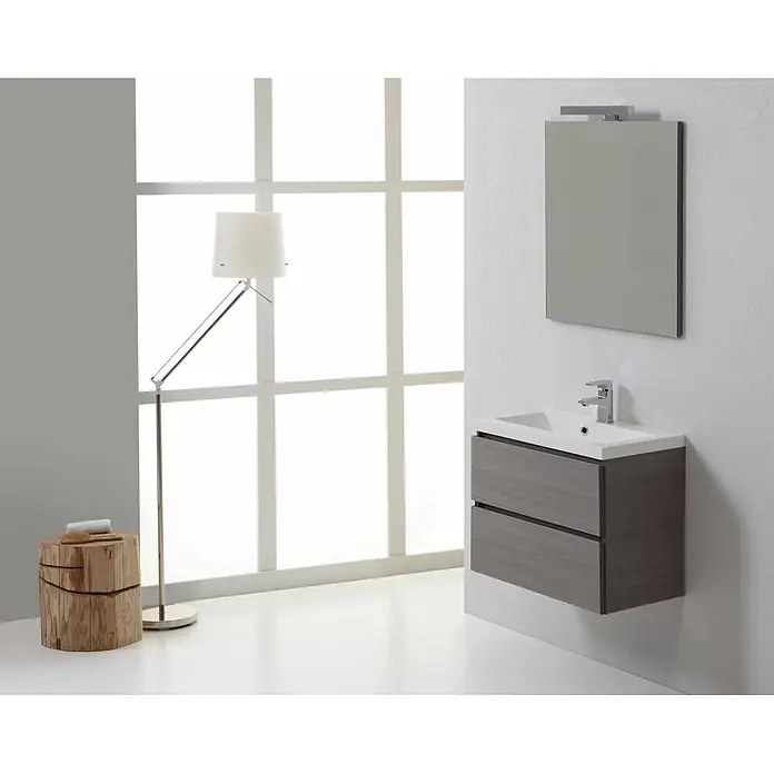 Kiamami Valentina Badmöbel-Set - Grau - Ein modernes Badezimmer mit einem grauen, schwebenden Waschtisch, weißem Waschbecken und Spiegel, einer silbernen Stehlampe und einem Naturholzschemel.