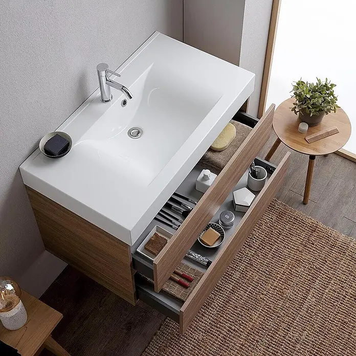Kiamami Valentina Badmöbel-Set - Braun - Moderner Badunterschrank mit weißem Waschbecken und Holzoptik-Schrank. Offene Schubladen zeigen organisierte Toilettenartikel.