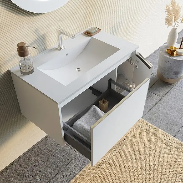 Kiamami Valentina Badmöbel-Set - Weiß - Weiße, wandmontierte Badezimmereinheit mit integriertem Waschbecken und teils geöffneter Schublade mit grauem Organizer.