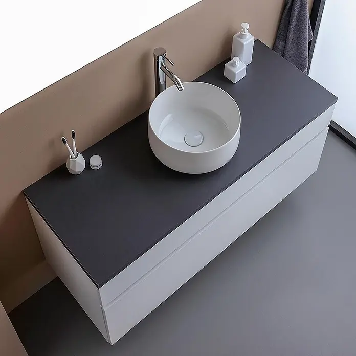Kiamami Valentina Badmöbel-Set - Weiß - Moderner weißer Badunterschrank mit dunkelgrauer Arbeitsplatte, rundem weißen Aufsatzwaschbecken, Chromarmatur und Badzubehör.