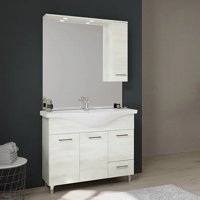 Kiamami Valentina Badmöbel-Set - Helles Holz - Badezimmermöbel aus hellem Holz mit weißem Waschbecken, beleuchtetem Spiegel und Schränken im modernen Badambiente.