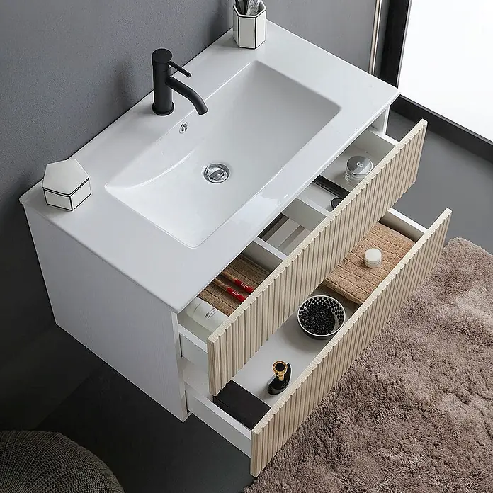 Kiamami Valentina Badmöbel-Set - Braun - Weißer Badezimmerschrank mit integriertem Waschbecken und schwarzem Wasserhahn. Zwei offene Schubladen mit gerillten Holzfronten zeigen organisierten Stauraum.