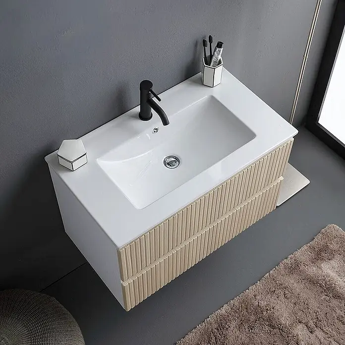 Kiamami Valentina Badmöbel-Set - Braun - Weißer Keramik-Waschtisch mit schwarzem Wasserhahn und hellen Holzlamellenfronten.