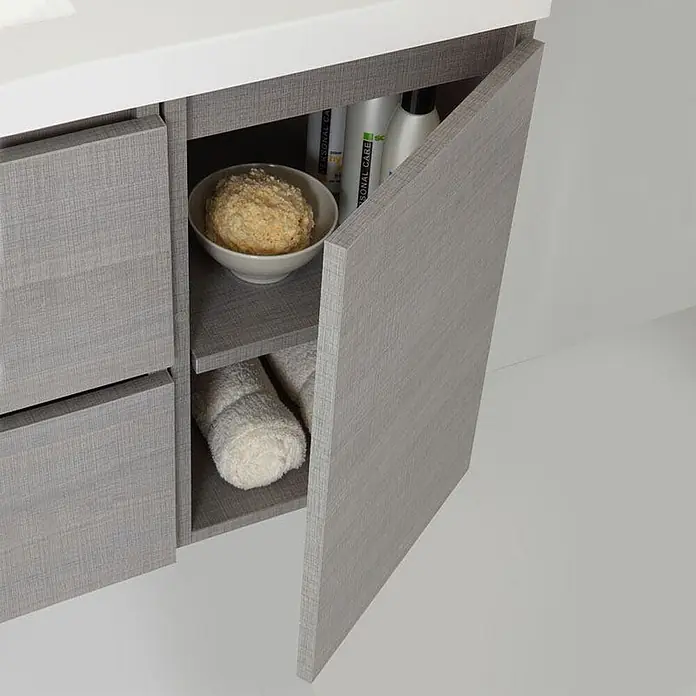Kiamami Valentina Badmöbel-Set - Grau - Grauer Waschtischunterschrank mit Holzmaserung und weißer Platte, offene Tür zeigt Ablagen mit Toilettenartikeln und Handtüchern.
