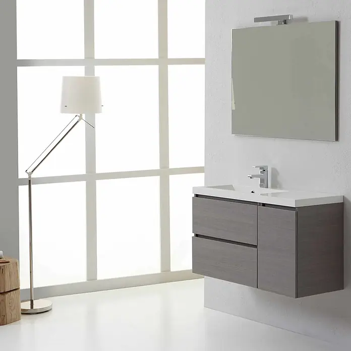 Kiamami Valentina Badmöbel-Set - Grau - Ein modernes, wandmontiertes Badezimmerwaschtisch in grauer Holzoptik mit integriertem weißen Waschbecken, Armatur und Spiegel mit Leuchte.