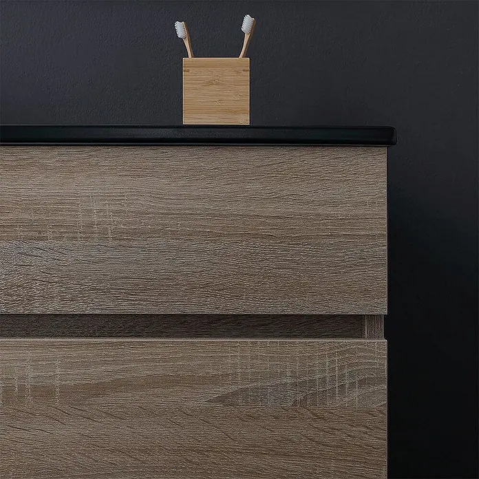 Kiamami Valentina Badmöbel-Set - Helles Holz - Badmöbel in heller Holzoptik mit schwarzer Ablage und Bambus-Zahnbürstenhalter vor dunkler Wand.