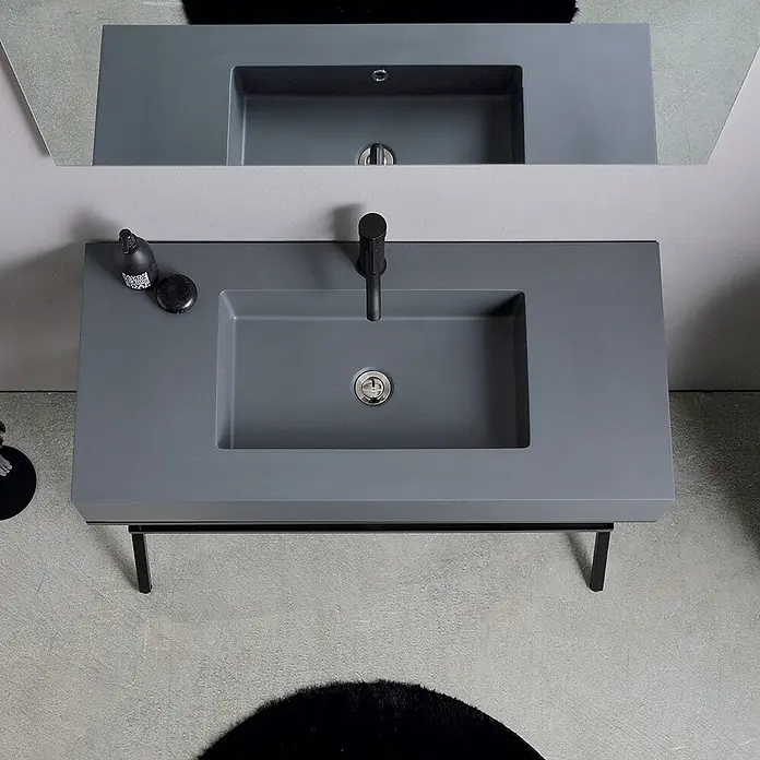 Kiamami Valentina Badmöbel-Set - Grau - Modernes graues Badewaschbecken mit integriertem Waschbecken und schwarzem Wasserhahn auf minimalistischem schwarzem Metallgestell.