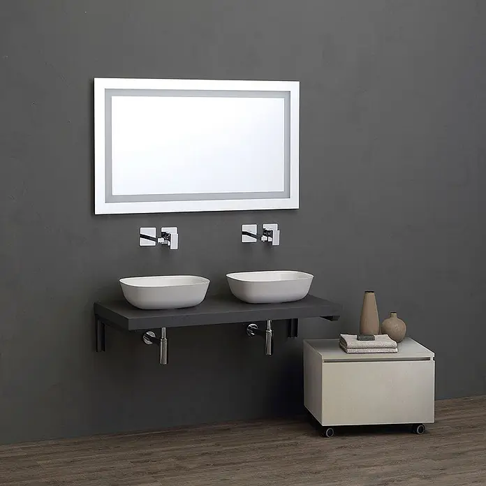 Kiamami Valentina Badmöbel-Set - Grau - Modernes Doppelwaschtisch-Badezimmer mit LED-Spiegel, zwei weißen Aufsatzwaschbecken auf dunkler Ablage und rollbarem Unterschrank.