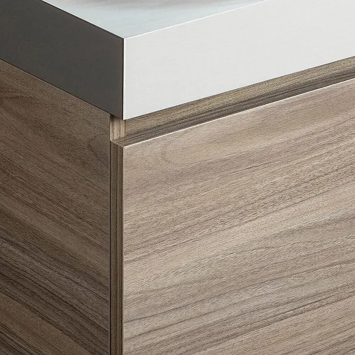 Kiamami Valentina Badmöbel-Set - Holz mittel - Moderne Schrankeinheit mit weißer Arbeitsplatte und heller Holzmaserung an Front und Seitenverkleidung.