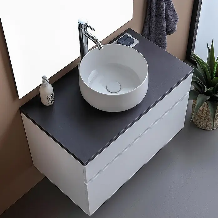 Kiamami Valentina Badmöbel-Set - Weiß - Weißer Badschrank mit dunkelgrauer Platte, Chromarmatur und runder weißer Keramik-Aufsatzwaschschale.