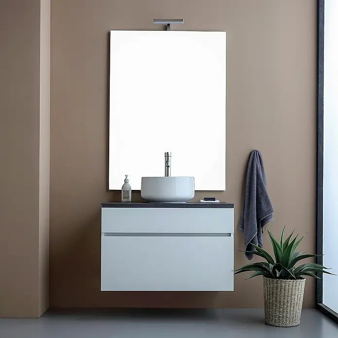 Kiamami Valentina Badmöbel-Set - Weiß - Moderner schwebender Badschrank mit weißem Aufsatzwaschbecken, hellgrauem Unterschrank, dunkler Arbeitsplatte und großem Spiegel mit Leuchte im Bad.