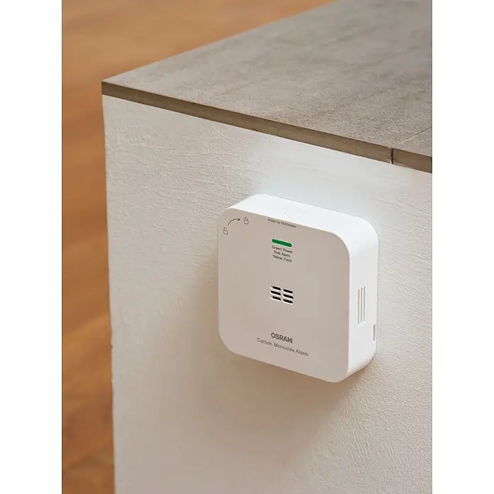 Ledvance Smart+ WiFi Kohlenmonoxidmelder - L x B x H: 8,5 x 2,73 x 8,5 cm, Batterielaufzeit: 5 Jahre - Weißer Osram Kohlenmonoxidmelder, rechteckig mit abgerundeten Ecken, an einer Wand montiert. Zeigt Statusleuchten für Strom, Alarm, Fehler an.