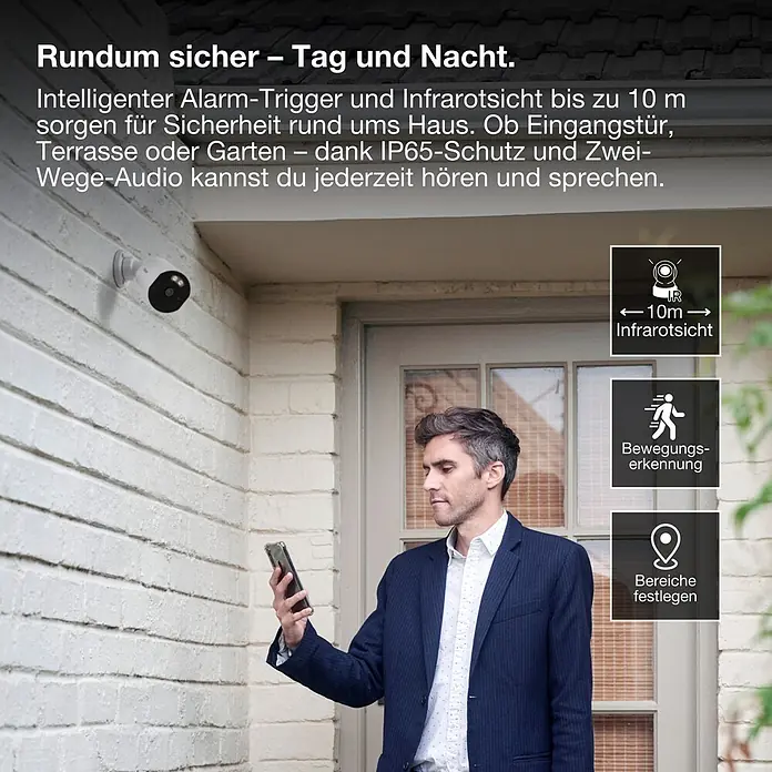 Osram Smart+ Überwachungskamera Outdoor Fixed - Weiß - Weiße Außenkamera an einer Hauswand, ein Mann prüft sein Smartphone; zeigt 10m Infrarot, Bewegungserkennung und Zwei-Wege-Audio.