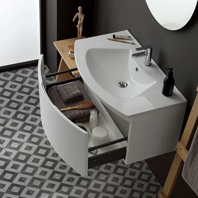 Kiamami Valentina Badmöbel-Set - Weiß - Weißer Badezimmerschrank mit integriertem Waschbecken und offener, gekrümmter Schublade, die Handtücher und Toilettenartikel zeigt.