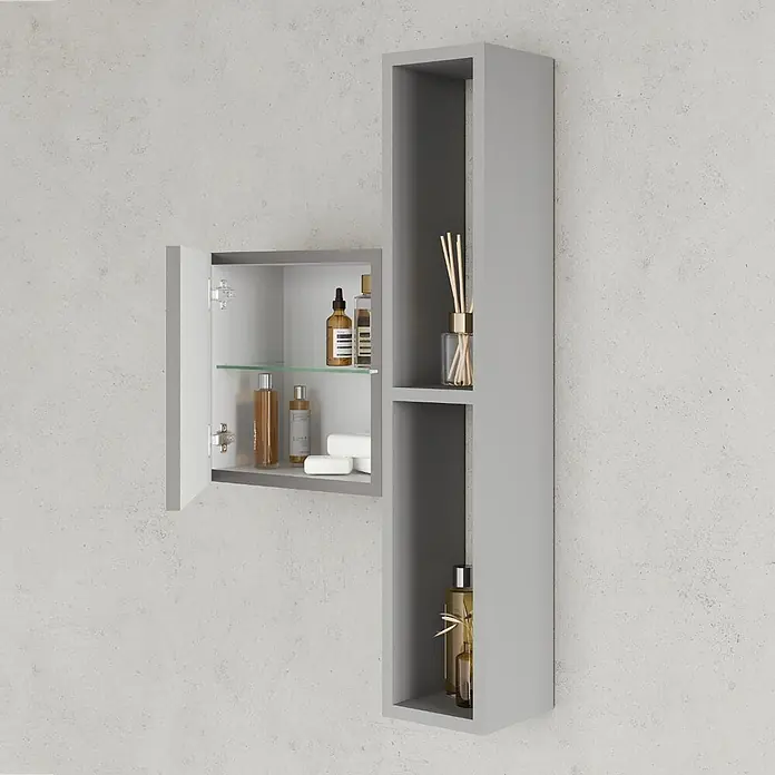 Kiamami Valentina Badmöbel-Set - Grau - Grauer wandmontierter Badezimmerschrank mit offener Tür, Glasablage und daneben stehendem hohem Regal.