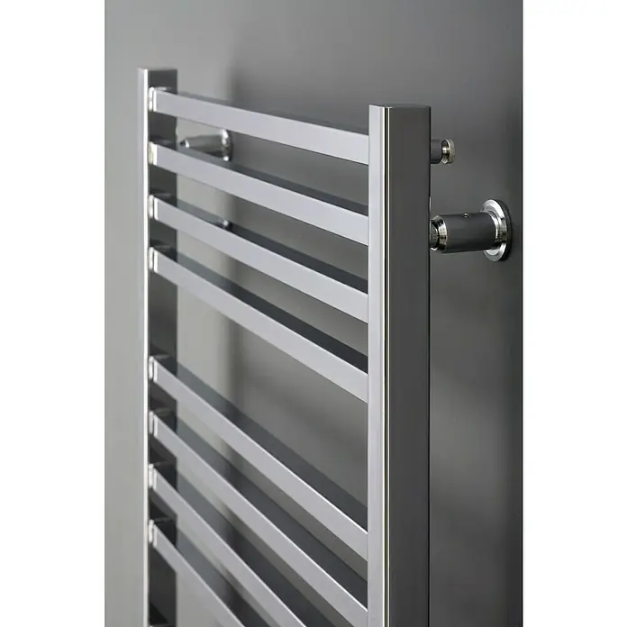 Ximax Badheizkörper C4 - B x H: 600 x 740 mm, Wärmeleistung bei Vorlauftemperatur von 75 °C (D: 50): 236 W - Detailaufnahme eines modernen, silbernen Handtuchwärmers mit geradlinigem Design, montiert an einer dunklen Wand.