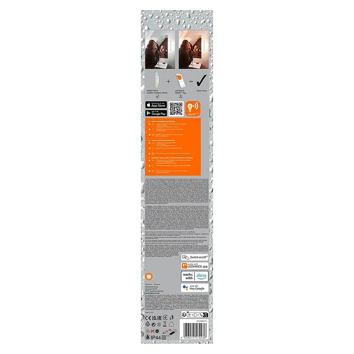 Ledvance Smart+ WiFi LED-Wandleuchte - 17 W, L x B x H: 40 x 7 x 5 cm, Weiß, Warmweiß - Abstimmbare weiße LED-Badleuchte mit Smart-Home-Integration, beleuchtet eine Frau vor einem Spiegel.