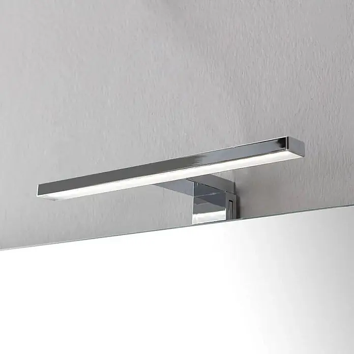 Kiamami Valentina Badmöbel-Set - Grau - Elegante Chrom-LED-Spiegelleuchte beleuchtet einen Spiegel.