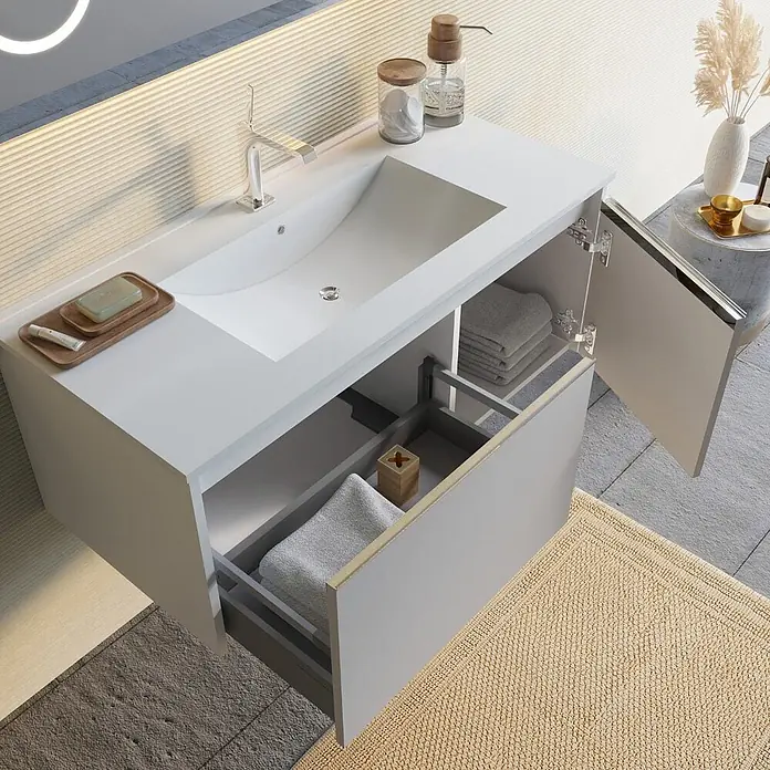 Kiamami Valentina Badmöbel-Set - Grau - Moderner Waschtisch in Weiß und Hellgrau mit integriertem Waschbecken, Chromarmatur, offener Schublade mit Handtüchern und offenem Schrank.
