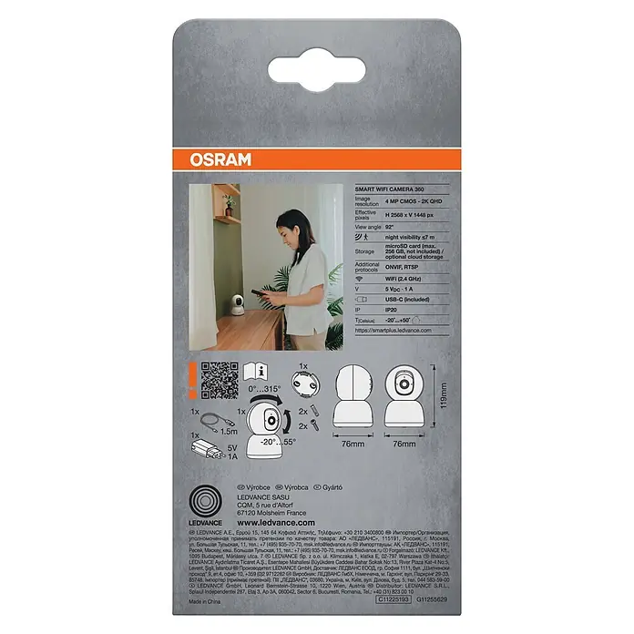 Osram Smart+ Überwachungskamera 360 - Weiß - Weiße OSRAM Smart WiFi Kamera 360 auf der Verpackung, eine Frau interagiert damit, technische Spezifikationen sind daneben.