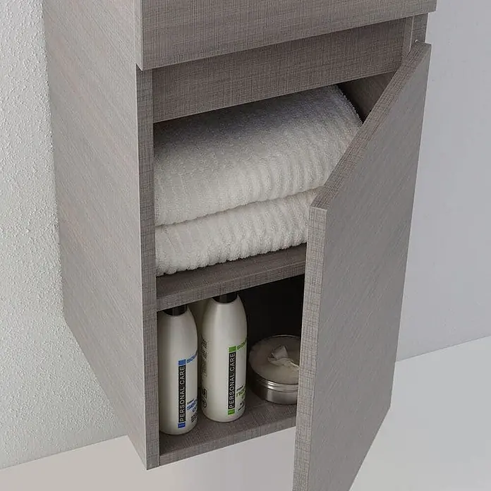 Kiamami Valentina Badmöbel-Set - Grau - Grauer Hängeschrank in Holzoptik mit offener Tür, in dem weiße Handtücher und Pflegeprodukte auf Regalen lagern.