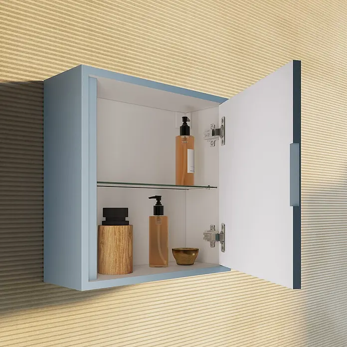 Kiamami Valentina Badmöbel-Set - Hellblau - Hellblauer wandmontierter Badezimmerschrank mit offener Tür, weißem Innenraum und Glasablage, gefüllt mit Badprodukten, vor gerippter Holzwand.