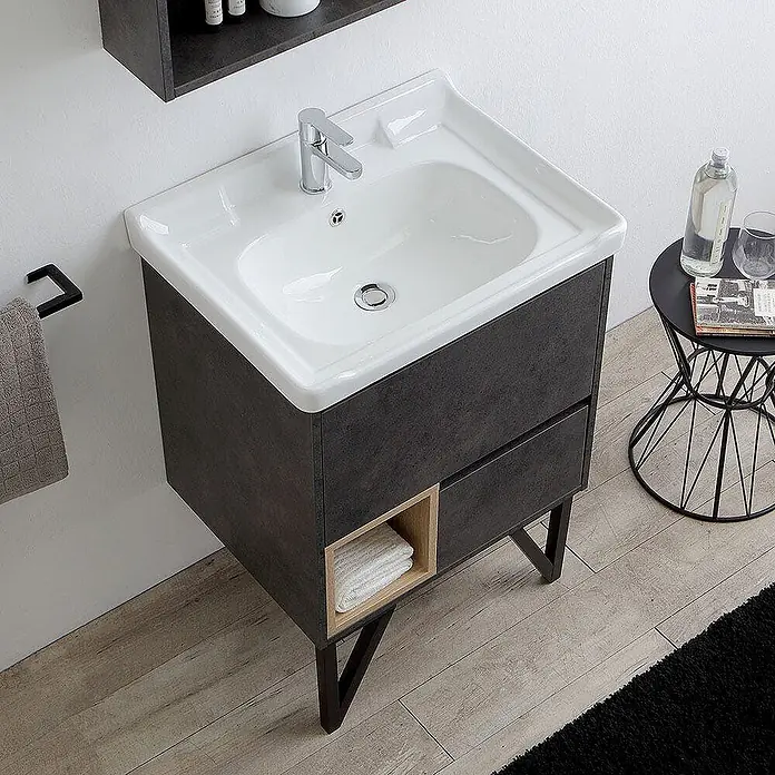 Kiamami Valentina Badmöbel-Set - Grau - Dunkelgrauer Badunterschrank mit weißem Keramikwaschbecken, Schublade und offenem Holzregal mit Handtuch, auf dunklen Metallbeinen.