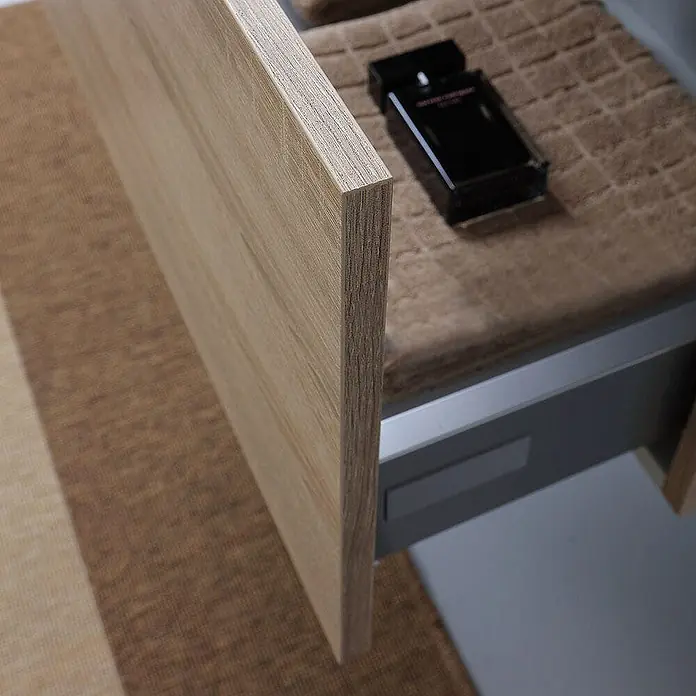 Kiamami Valentina Badmöbel-Set - Helles Holz - Geöffnete Schublade mit heller Holzmaserung, brauner Matte und schwarzer Parfümflasche.