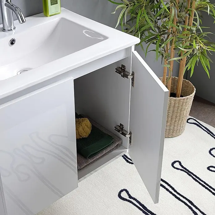 Kiamami Valentina Badmöbel-Set - Weiß - Weißer Badunterschrank mit integriertem Waschbecken, offenem Stauraum mit Handtüchern und Schwamm, in einem modernen Badezimmer.
