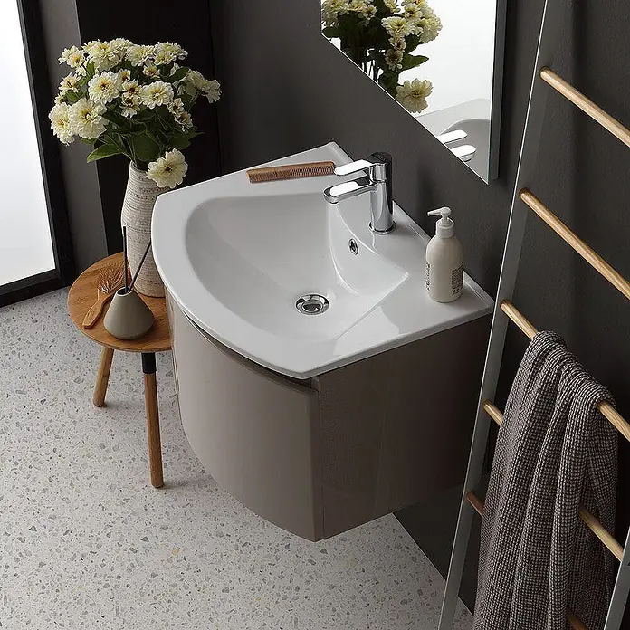 Kiamami Valentina Badmöbel-Set - Beige - Beige wandhängender Eckwaschtisch mit weißem Keramikbecken in modernem Badezimmer.