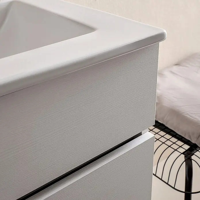 Kiamami Valentina Badmöbel-Set - Weiß - Hellgrauer Badschrank mit Holzmaserung, integriertem weißen Waschbecken und zwei grifflosen Schubladen.
