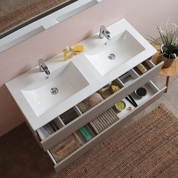 Kiamami Valentina Badmöbel-Set - Helles Holz - Helle Holzoptik-Doppelwaschtisch mit weißen Spülbecken und offenen Schubladen für Toilettenartikel und Handtücher.