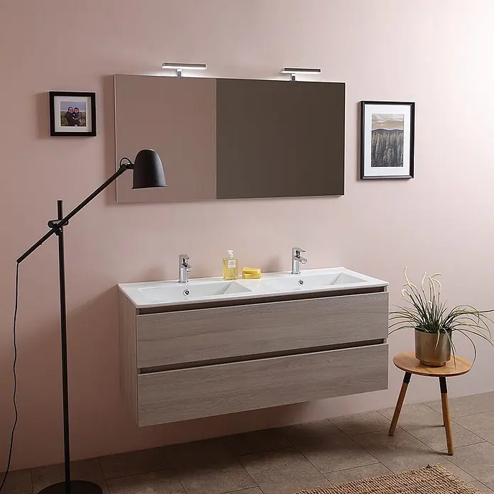 Kiamami Valentina Badmöbel-Set - Helles Holz - Modernes Doppelwaschbecken mit hellem Holzunterschrank, zwei weißen Spülbecken und Armaturen, unter großem Spiegel mit Leuchten.