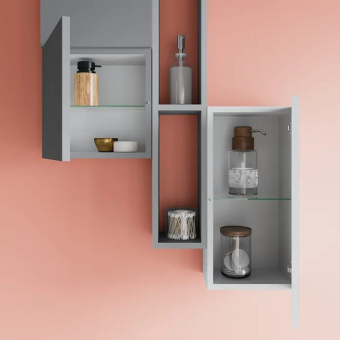 Kiamami Valentina Badmöbel-Set - Weiß - Modulares graues Badezimmer-Wandregal mit offenen Fächern, einem Schrank, orangen Rückwänden und Toilettenartikeln.