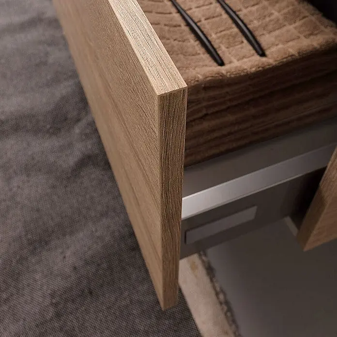 Kiamami Valentina Badmöbel-Set - Helles Holz - Teilweise geöffnete Schublade mit heller Holzmaserung, die braune Stoffstapel und schwarze Gegenstände auf grauem Inneren zeigt.
