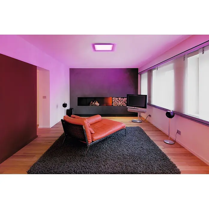 Osram Smart+ LED-Panel Planon Plus - L x B x H: 45 x 45 x 5,6 cm, Weiß, RGBW - Orangefarbenes Ledersofa auf dunkelgrauem Hochflorteppich in einem modernen Wohnzimmer.