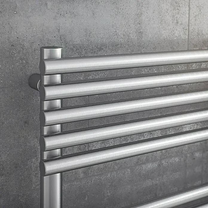 Ximax Badheizkörper Tec - B x H: 600 x 1.197 mm, Wärmeleistung bei Vorlauftemperatur von 75 °C (D: 50): 515 W - Nahaufnahme eines modernen, horizontalen Handtuchwärmers aus gebürstetem Stahl an einer grauen Wand. Das Heizgerät besticht durch sein schlichtes Design.